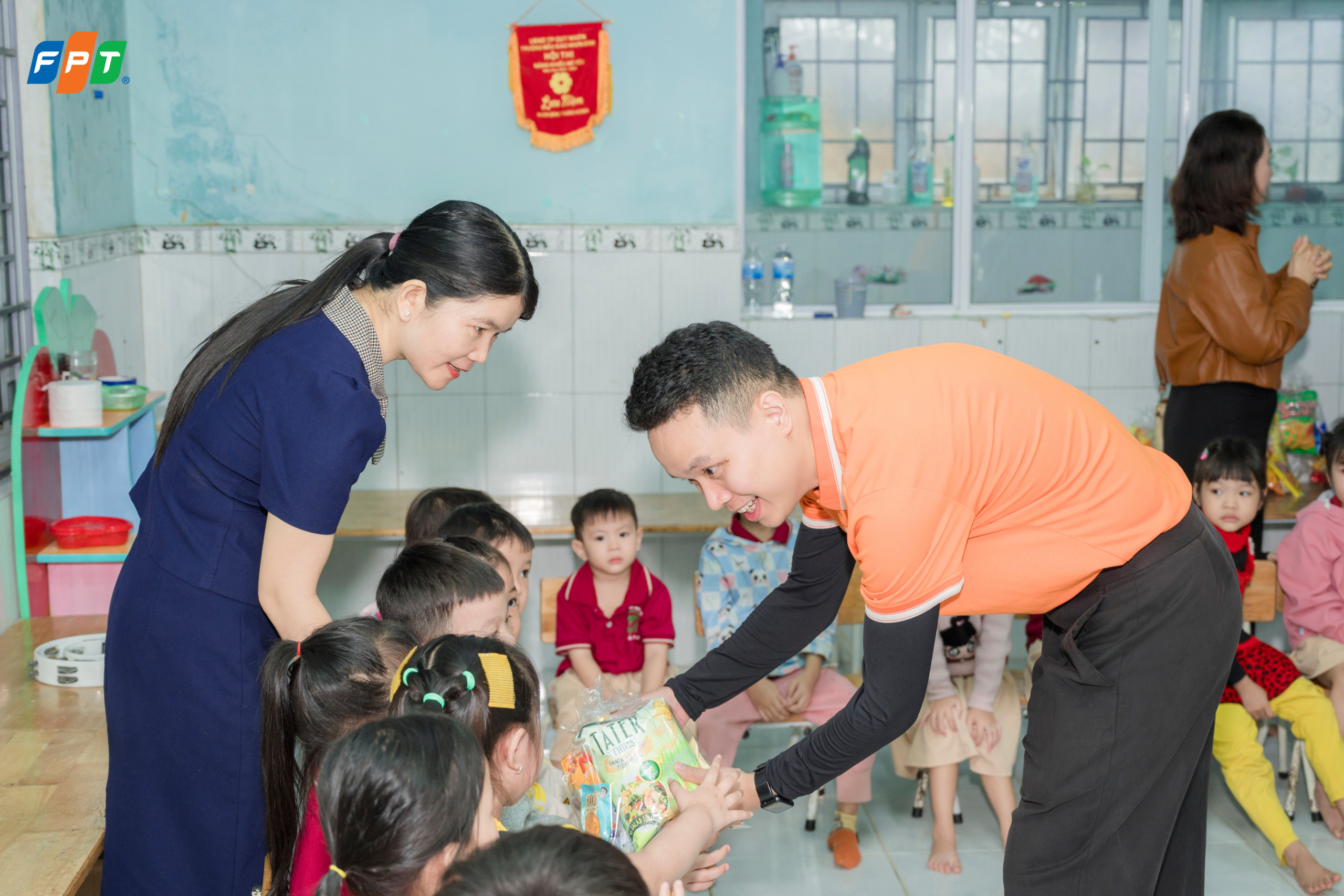 FPT Schools đồng hành lan tỏa yêu thương đến học sinh vùng bão lũ tại Gia Lai - FPT Education Ông Vũ Hồng Quân – Hiệu trưởng FPT School Thanh Hóa, Giám đốc Điều hành FPT School Quy Nhơn, Long Vân và Long An, đại diện FPT Schools trao quà cho các em nhỏ