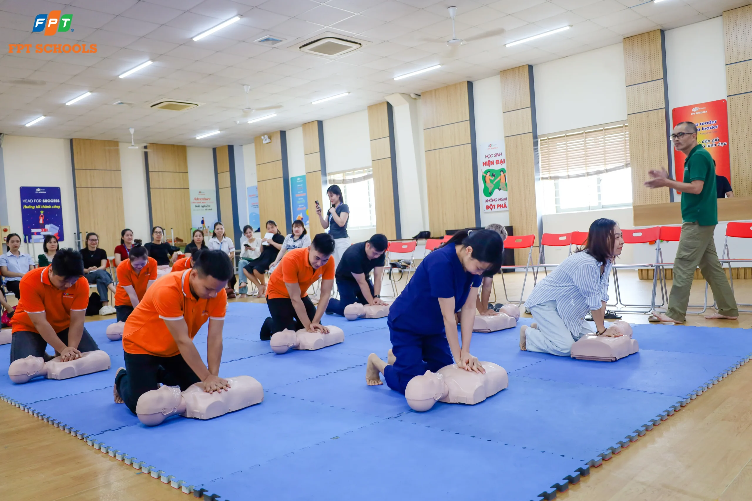 Cán bộ, giáo viên FPT School Cầu Giấy trực tiếp thực hành các kỹ năng sơ cấp cứu, hồi sức tim phổi (CPR) trên mô hình dưới sự hướng dẫn của chuyên gia y tế.